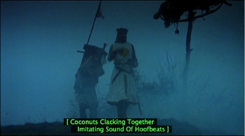 Scene shows King Arthur and Patsy on a misty moor with the caption [&nbsp;Coconuts Clacking Together Imitating Sound of Hoofbeats&nbsp;]